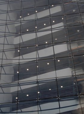 Alacakaranlıkta aydınlanan modern cam ofis binasının merdiven ve zeminlerini birleştirmek