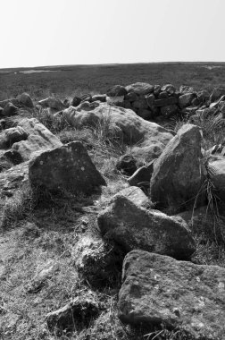 Calderdale, Batı Yorkshire 'daki Midgley bataklığında yer alan değirmencilerin mezarı olarak bilinen Cairn' in tepesindeki taşları ortaya çıkardı.