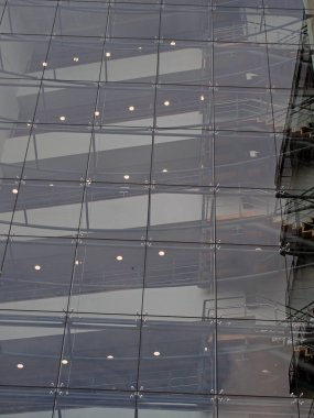 Alacakaranlıkta aydınlanan modern cam ofis binasının merdiven ve zeminlerini birleştirmek