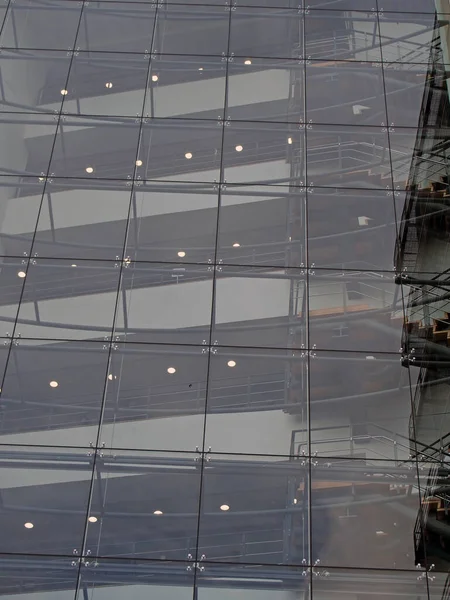 Alacakaranlıkta aydınlanan modern cam ofis binasının merdiven ve zeminlerini birleştirmek