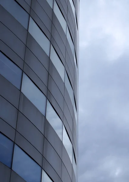 푸르스름 창문들이 줄줄이 늘어서 거대하고 현대식 사무실 건물의 사항들을 가까이 — 스톡 사진