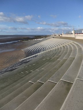 Blackpool, Lancashire, Birleşik Krallık - 4 Mart 2022: Blackpool 'da deniz kenarında gezinen ve parlak güneş ışığı altında adımları olan insanlar