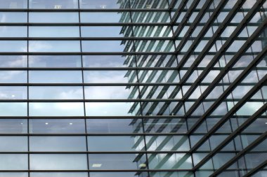 tam kare modern şehir ofis mimarisi geometrik şekilli binalar gökyüzü ve bulutlar mavi cam pencerelere yansıyor