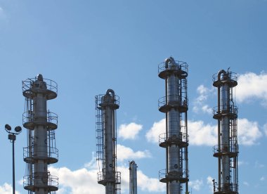 tall steel fractionation or cooling towers at a large industrial chemical plant clipart