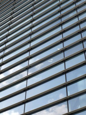 modern ofis mimarisi geometrik ile soyut gökyüzü eğimli mavi cam pencerelere yansıdı