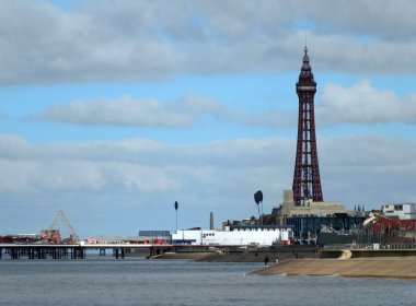 Blackpool, Lancashire, Birleşik Krallık - 5 Mart 2022: Güneyden Blackpool manzaralı, merdivenlerde dalgalar kırılıyor, insanlar gezinti güvertesinde ve orta mil ve kulede