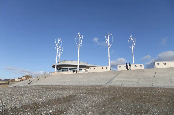 Blackpool, Lancashire, Birleşik Krallık 'taki Cleveland' daki sahil şeridi boyunca yürüyen insanlar - 4 Mart 2022 - Kafe ve modern rüzgar türbinleriyle Blackpool