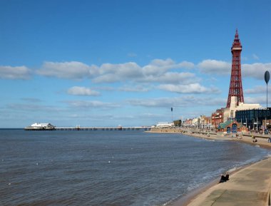 Blackpool, Lancashire, Birleşik Krallık - 5 Mart 2022: Kuzey rıhtım binaları ve kule mavi bulutlu gökyüzü ile denize yansıyan Blackpool manzarası