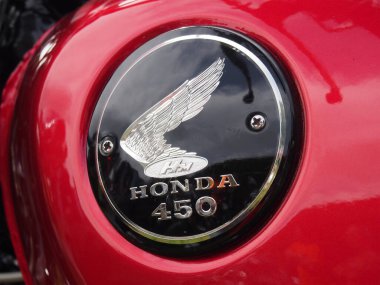 hebden bridge, west, yorkshire, united kingdom - 7 August 2022: close up of a black and chrome honda logo on the tank of a red vintage 450 motorcycle