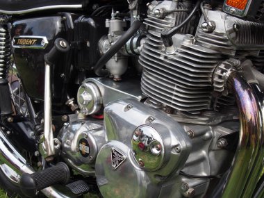 hebden bridge, west, yorkshire, united kingdom - 7 August 2022: close up of the engine and badge of a black vintage triumph trident motorcycle at hebden bridge vintage weekend