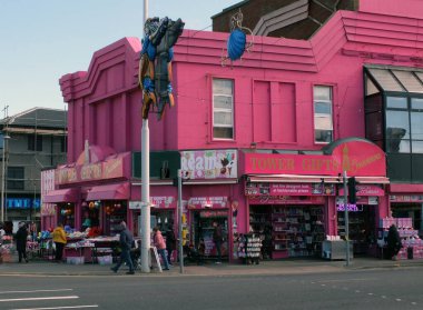 Blackpool, Lancashire, United Kingdom - 5 March 2022: people walking past the tower gifts and ice cream shop on the promenade in Blackpool