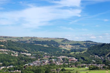 Calderdale Batı Yorkshire 'daki köy ve mitolmroyd' un panoramik manzarası yaz ağaçları ve çayırlarla çevrili.
