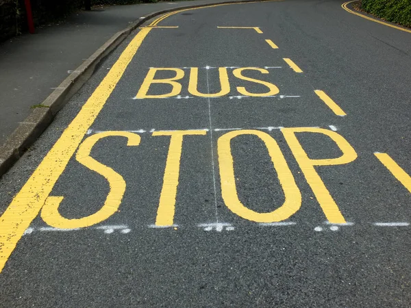 Újonnan Festett Sárga Buszmegálló Útjelző Tábla Jelzések Egy Fekete Aszfalton — Stock Fotó