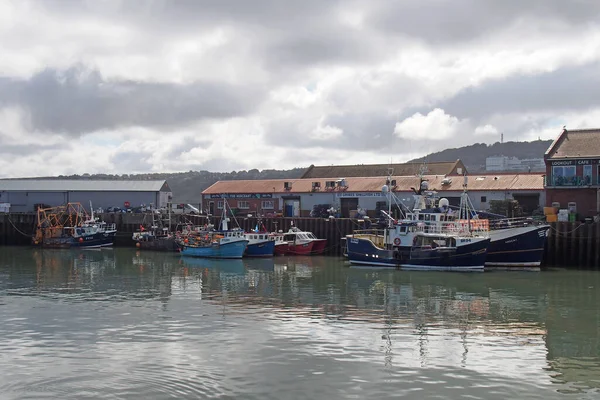 Scarborough, Kuzey Yorkshire, İngiltere - 11 Eylül 2022: Scarborough limanında liman binaları olan balıkçı tekneleri ve balıkçılar