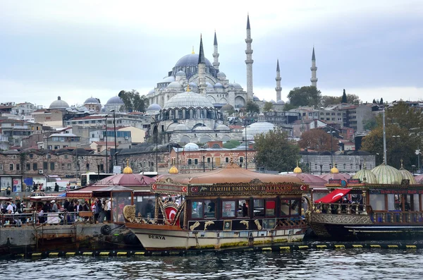 A view from Galata Bridge Traditional fish restaurant by the sea and the Suleymaniye Mosque in the background, Istanbul
