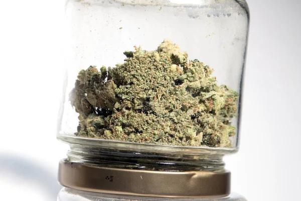 白い背景のガラス瓶のマリファナと大麻の芽 — ストック写真