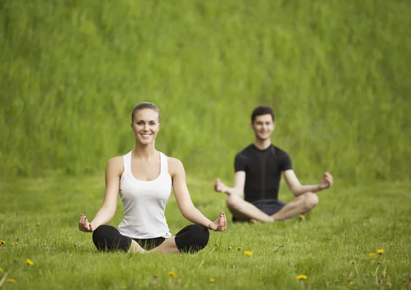 Giovane coppia meditare insieme, all'aperto — Foto Stock