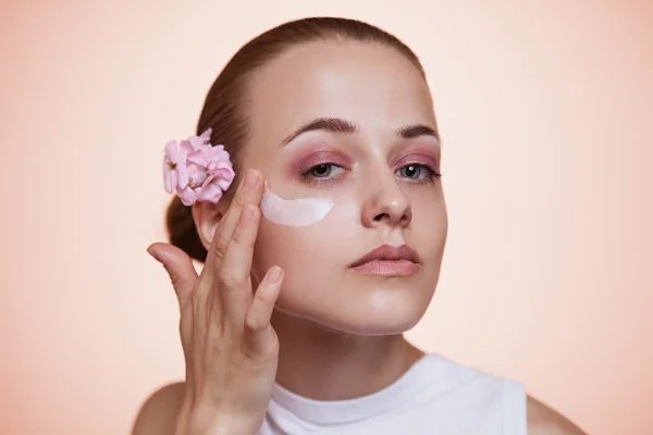 Girl uses cream — Stock Photo, Image