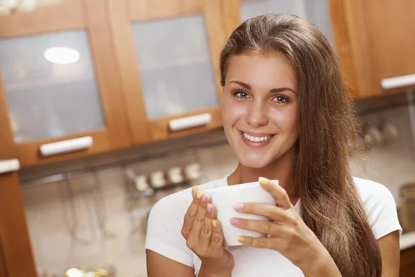 Menina segurando uma caneca e sorrindo — Fotografia de Stock