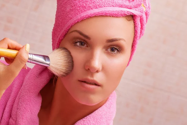 Girl looks in the mirror doing makeup — Stock Photo, Image