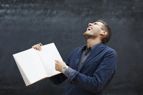 Alegre profesor muestra en el libro y se ríe — Foto de Stock