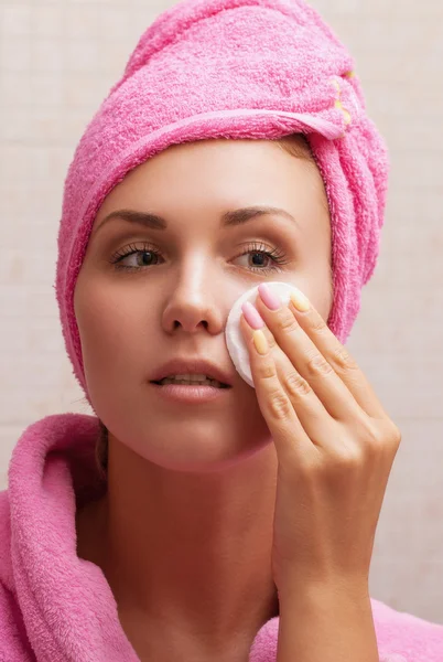 Girl cleans the face with a cotton pad Royalty Free Stock Photos