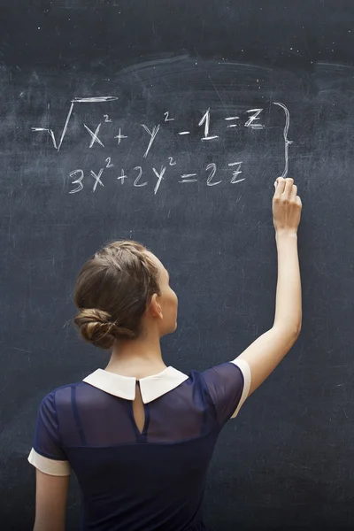 Hermosa escritura de estudiante en pizarra con tiza — Foto de Stock