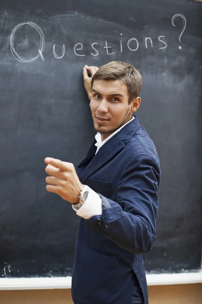 Jeune professeur écrivant sur un tableau noir à la craie — Photo