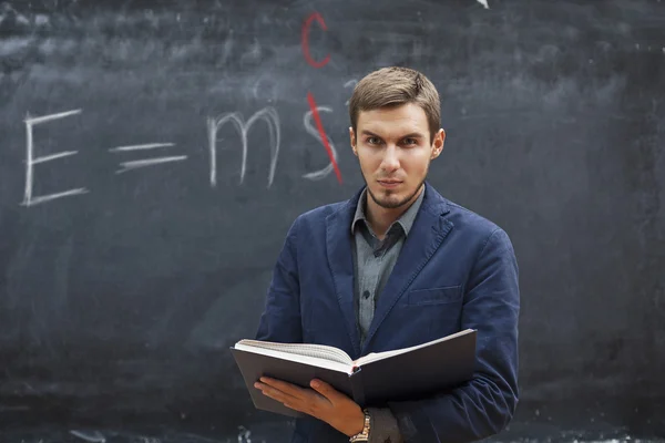 Profesor con los costos del libro de texto alrededor de la junta con la inscriptio — Foto de Stock