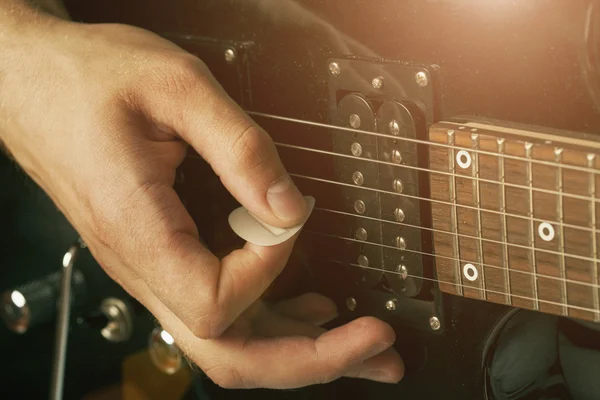 Guy holding a guitar pick — Stock Photo, Image