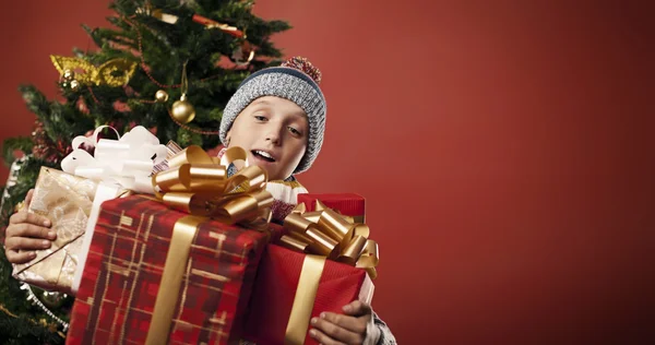 Een jongen geniet een heleboel geschenken — Stockfoto