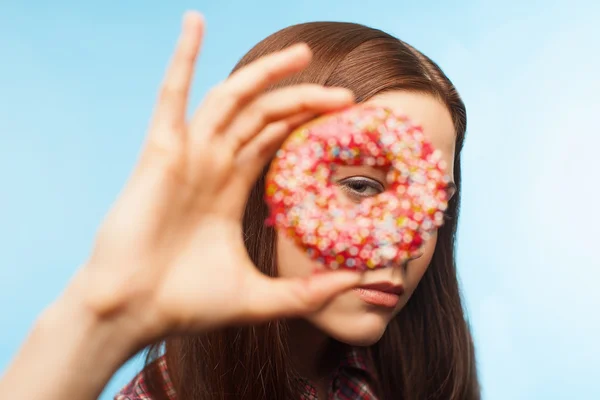 Meisje op zoek via een donut — Stockfoto