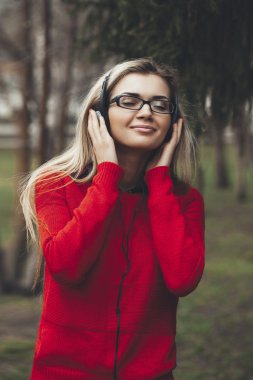  girl listening to MP3 player on the street