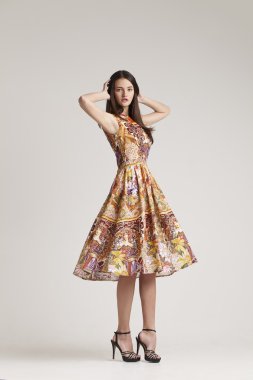 gri arka plan üzerinde poz elbiseli genç bayan