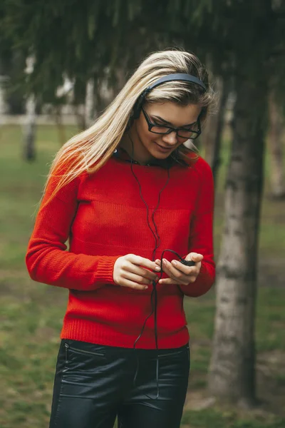 Молода дівчина слухає MP3 гравця в парку — стокове фото