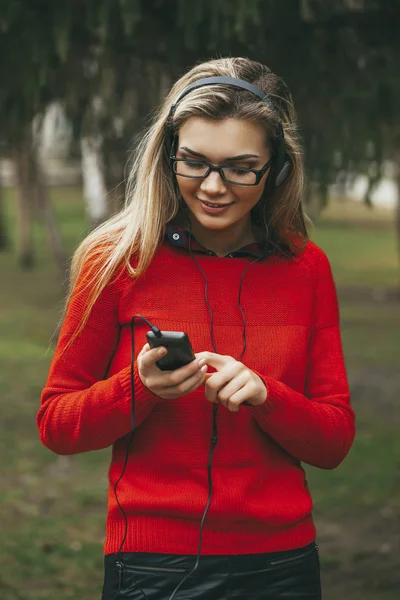 Mooi meisje luisteren naar mp3-speler op de straat, park — Stockfoto