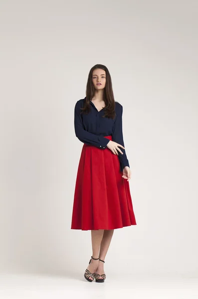 Jonge dame in jurk die zich voordeed op grijze achtergrond. rood — Stockfoto