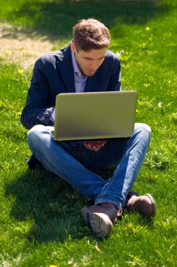 çimenlerin üzerinde genç iş adamı. moda stil. Skype konuşurken. o
