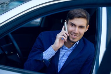 genç iş adamı arabaya. moda stil. Skype konuşurken. Out