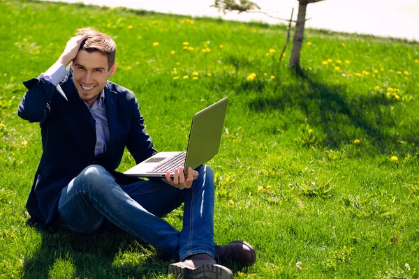 Junger Geschäftsmann auf dem Rasen. Mode-Stil. Skype sprechen. o — Stockfoto