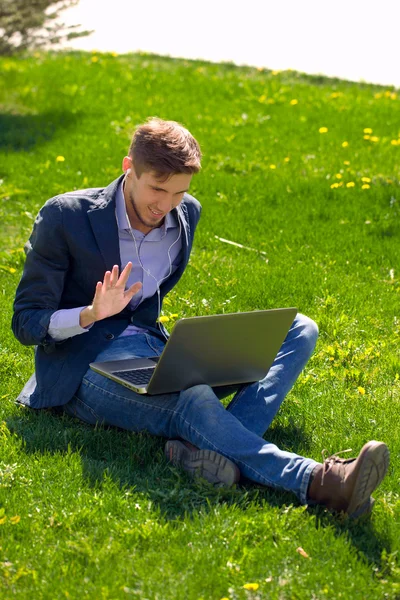 Uomo d'affari sull'erba. stile di moda. skype parlante . — Foto Stock