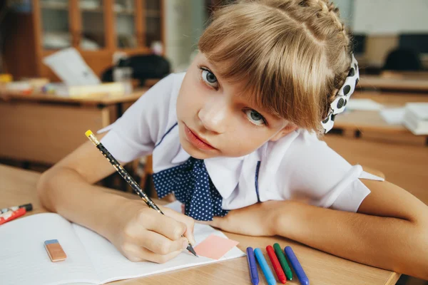 Little girl at the desk is writing — Stock Photo, Image