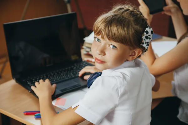 Školačka pomocí její laptop ve škole — Stock fotografie