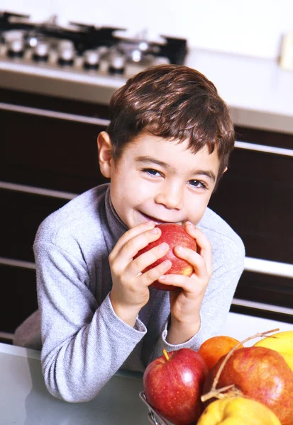 Baby i kök äta äpple — Stockfoto