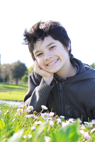 12 anos de idade menino solar na grama verde — Fotografia de Stock