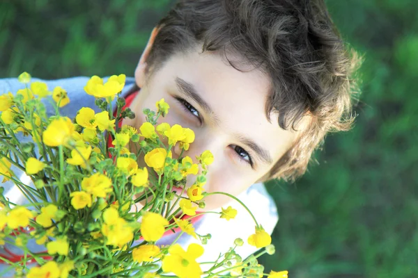 Elinde çiçeklerle çocuk gülümseyen — Stok fotoğraf