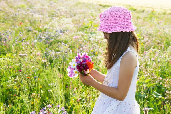Dívka sbírá květiny — Stock fotografie
