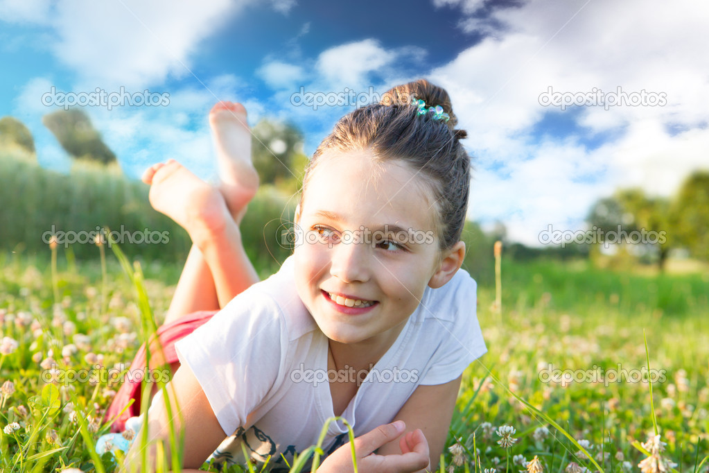 Girl lying on green grass