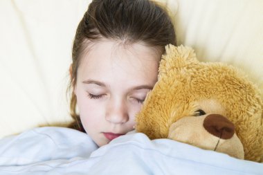 oyuncak ayı ile uyuyan kız