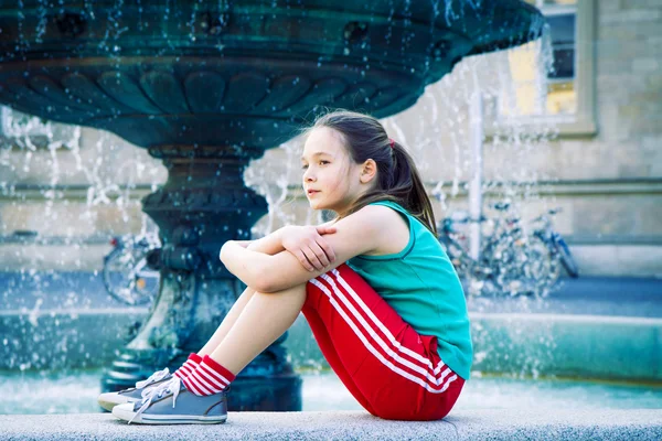 Ragazza seduta alla fontana — Foto Stock